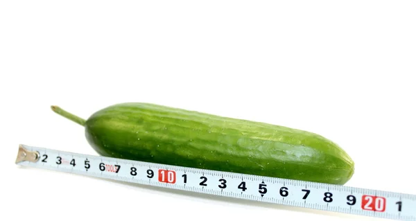 Grote komkommer en een meetlint op wit — Stockfoto
