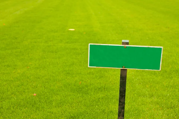 stock image Green grass with a sign, horizontal shot