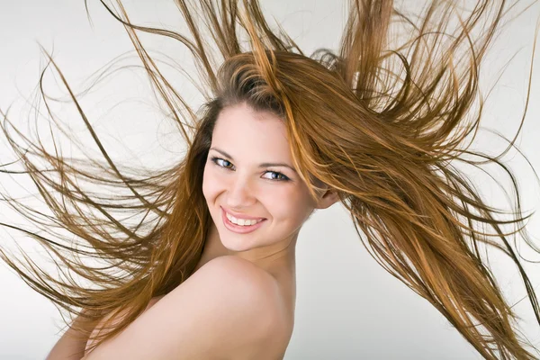 Veselá mladá žena s vývojem vlasy — Stock fotografie