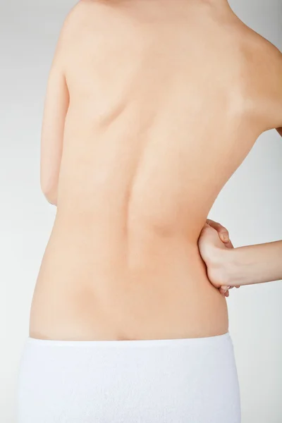 Mujer sosteniendo su dolorosa espalda — Foto de Stock