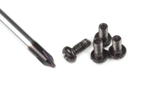 Screwdriver and four screws — Stock Photo, Image