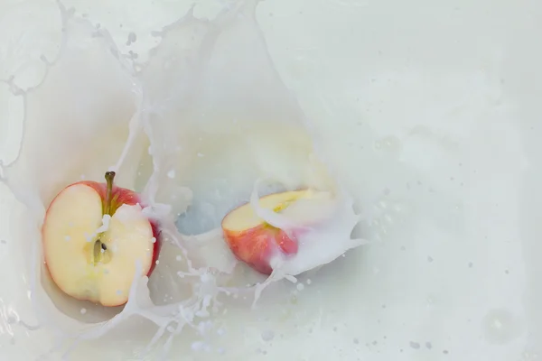 Jablko a stříkající mléko — Stock fotografie