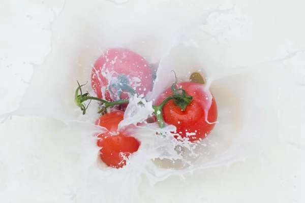 Tomato and splashing milk — Stock Photo, Image