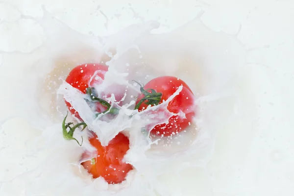 Tomate e leite em salpicos — Fotografia de Stock