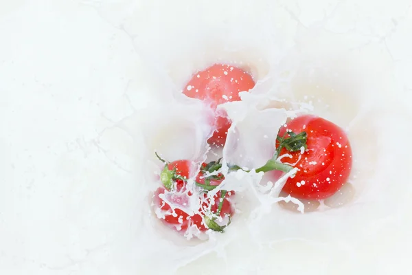 Tomato and splashing milk — Stock Photo, Image