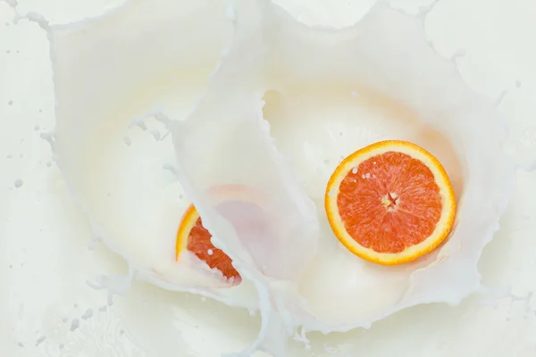 Orange and splashing milk — Stock Photo, Image