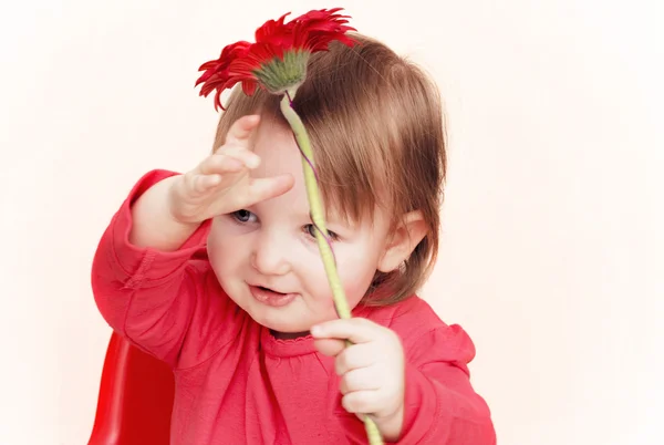 Liten flicka med röd blomma — Stockfoto