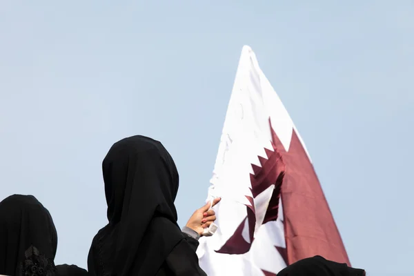 Mulheres cobertas e bandeira do Qatar — Fotografia de Stock
