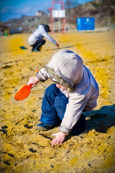 Kleine jongen graaft in zand — Stockfoto