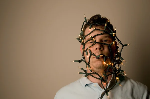 Man wrapped in Christmas lights — Stock Photo, Image