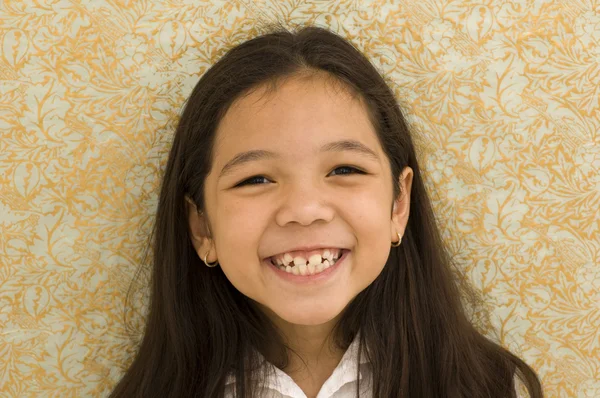 Asiatico ragazza sorridente contro modello carta sfondo — Foto Stock