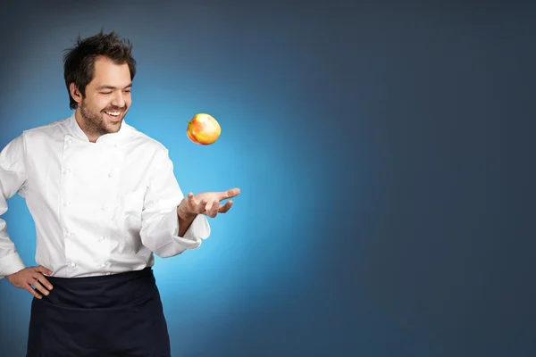 Young chef playing with apple — Stock Photo, Image