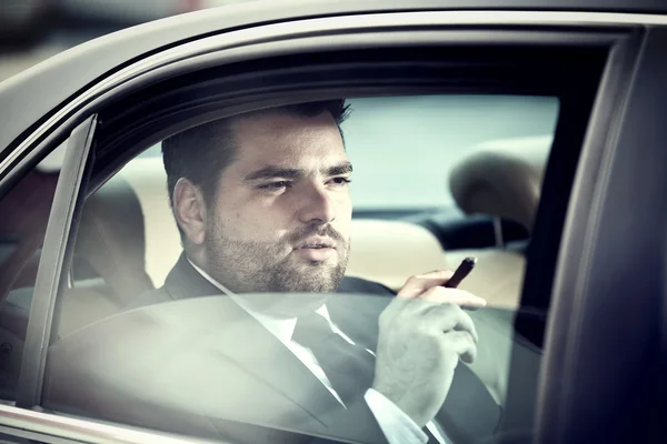 Hombre en el asiento trasero de un coche fumando —  Fotos de Stock