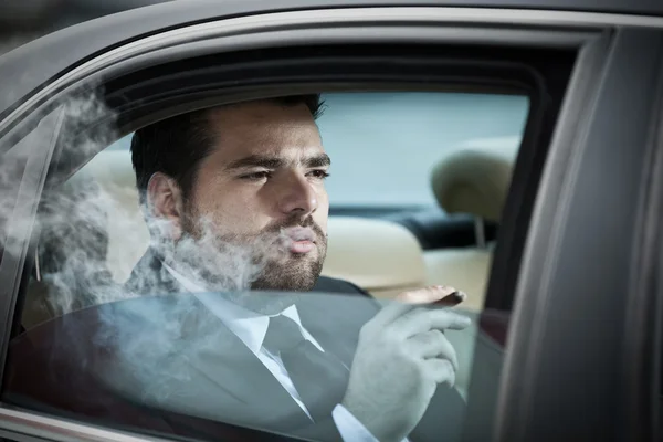 Άνθρωπος στο πίσω κάθισμα του καπνίσματος ένα αυτοκίνητο — Φωτογραφία Αρχείου