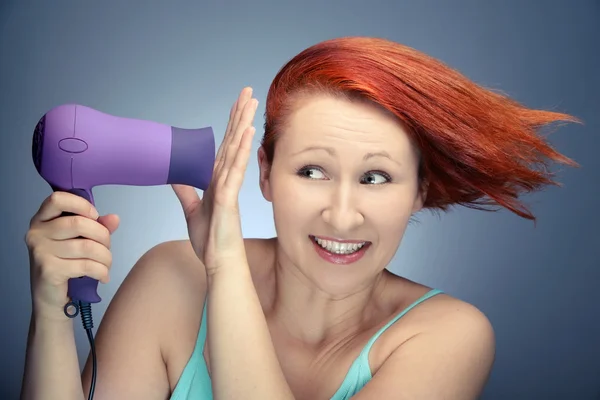Рыжая женщина сушит волосы — стоковое фото