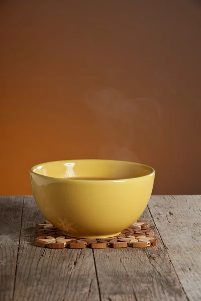 Sopa caliente en tazón amarillo —  Fotos de Stock