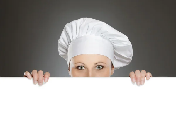 Vrouwelijke chef-kok kijkt uit over billboard — Stockfoto