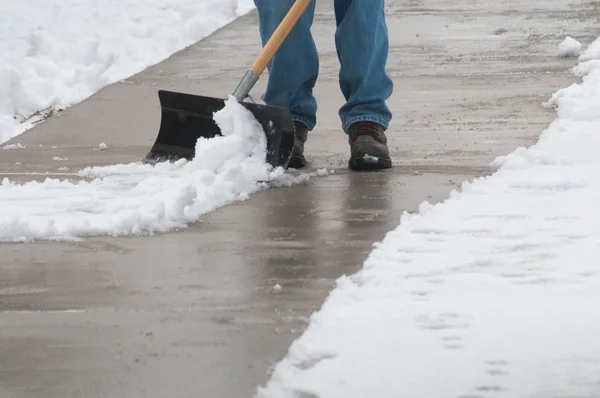 Limpando a neve da caminhada Fotos De Bancos De Imagens