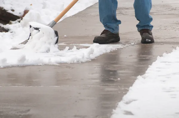 Limpando a neve da caminhada Fotografia De Stock