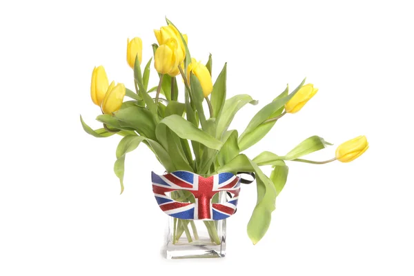 Tulipas amarelas em um vaso com máscara britânica — Fotografia de Stock