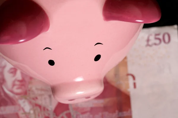 Piggybank con billete de cincuenta libras —  Fotos de Stock