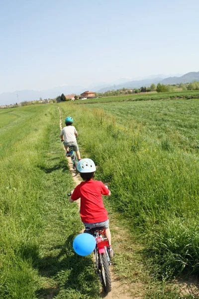Niños en bicicleta a lo largo de las orillas — Foto de Stock