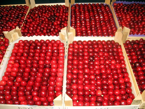 Красные вишни рядом друг с другом, готовые к продаже в продуктовом — стоковое фото