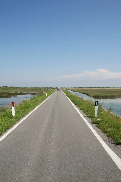 Lunga strada asfaltata nella laguna veneziana — Foto Stock