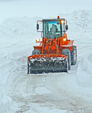 Snow plow clears the streets during a snow storm clipart