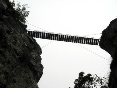 Suspension bridge in the mountains clipart