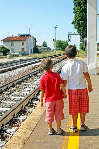 Два брата, дети ждут на вокзале — стоковое фото