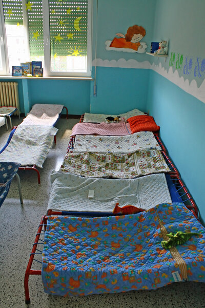 Dormitory for children with small beds and blankets for a kindergarten