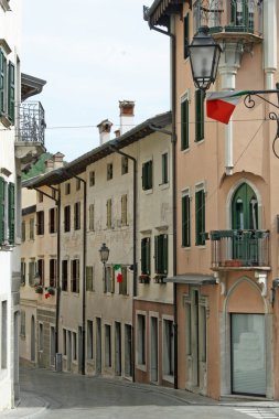 Narrow country road in Friuli Gemona with Italian flags clipart