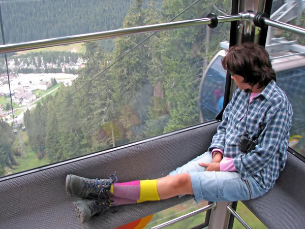 Woman sitting on the cabin of a cable car — Stock Photo, Image