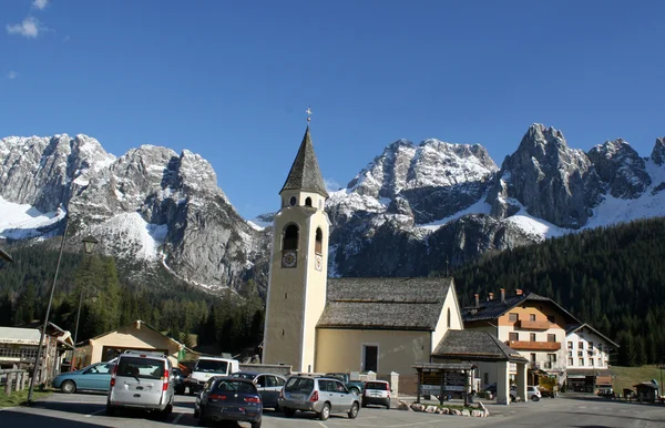 Bell Tower of a church and the background of the Dolomites in Ca — Stock Photo, Image