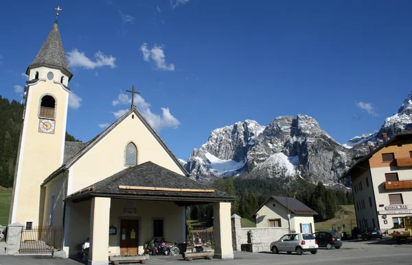 Klocktornet av en kyrka och bakgrunden till Dolomiterna i det — Stockfoto
