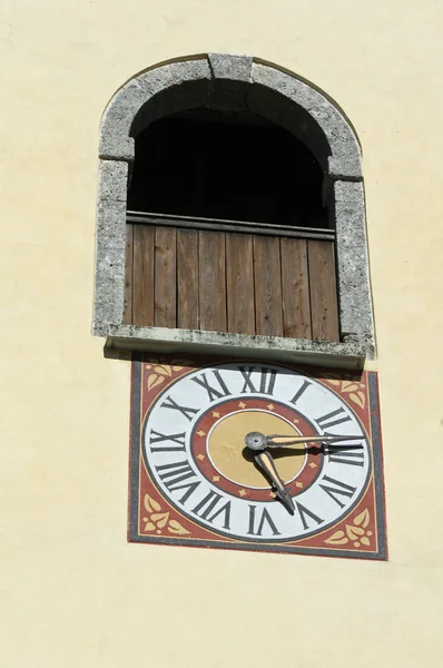 Hodiny s římskými číslicemi na zdi zvonice kostel — Stock fotografie