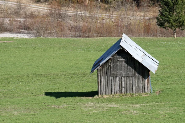 Ld dřevěná stodola uprostřed trávníku v Dolomitech — Stock fotografie