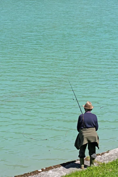 Fisherman to fish in a alpine blue Lake — Stock Photo, Image