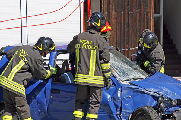 stock image Firefighters in action for free from a car, injured in a car acc