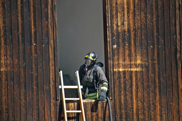 危険な火を離れたマスクと消防士 — ストック写真