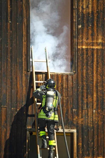Пожарные с кислородным баллоном, чтобы привязать лестницу к вывозу — стоковое фото