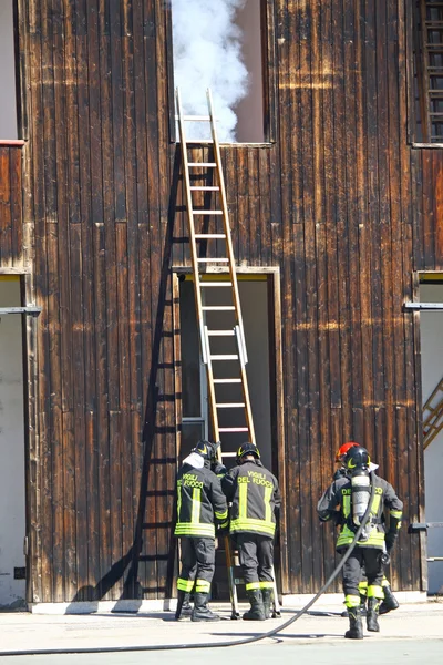 Bombeiros extinguir um incêndio com fumaça branca em seu st fogo — Fotografia de Stock