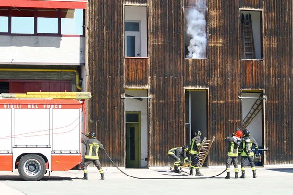Bombeiros durante um exercício e tentar desligar um incêndio — Fotografia de Stock