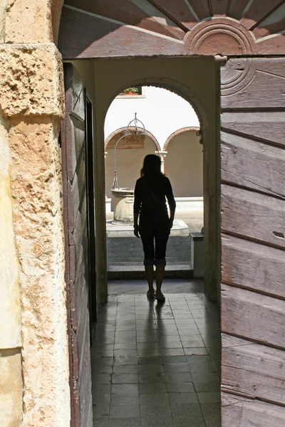 Eski bir manastırda bir kapı giren kadın — Stok fotoğraf