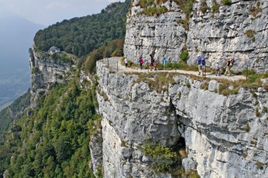 Family walks in the mountains on the edge of the ravine clipart