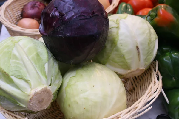 Зимняя продажа фиолетовой и зеленой капусты на рынке — стоковое фото