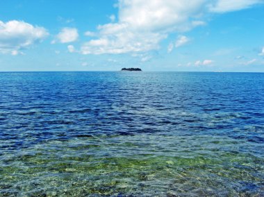 Yaz aylarında mavi bir deniz ortasında uzak atoll