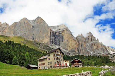 Alpine hut at the foot of the mountain in Val di Fassa clipart