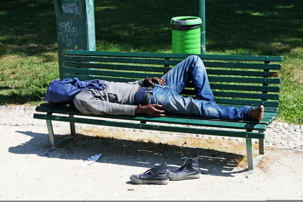 Fattiga marginaliserade hemlösa sover i en utomhus bänk — Stockfoto